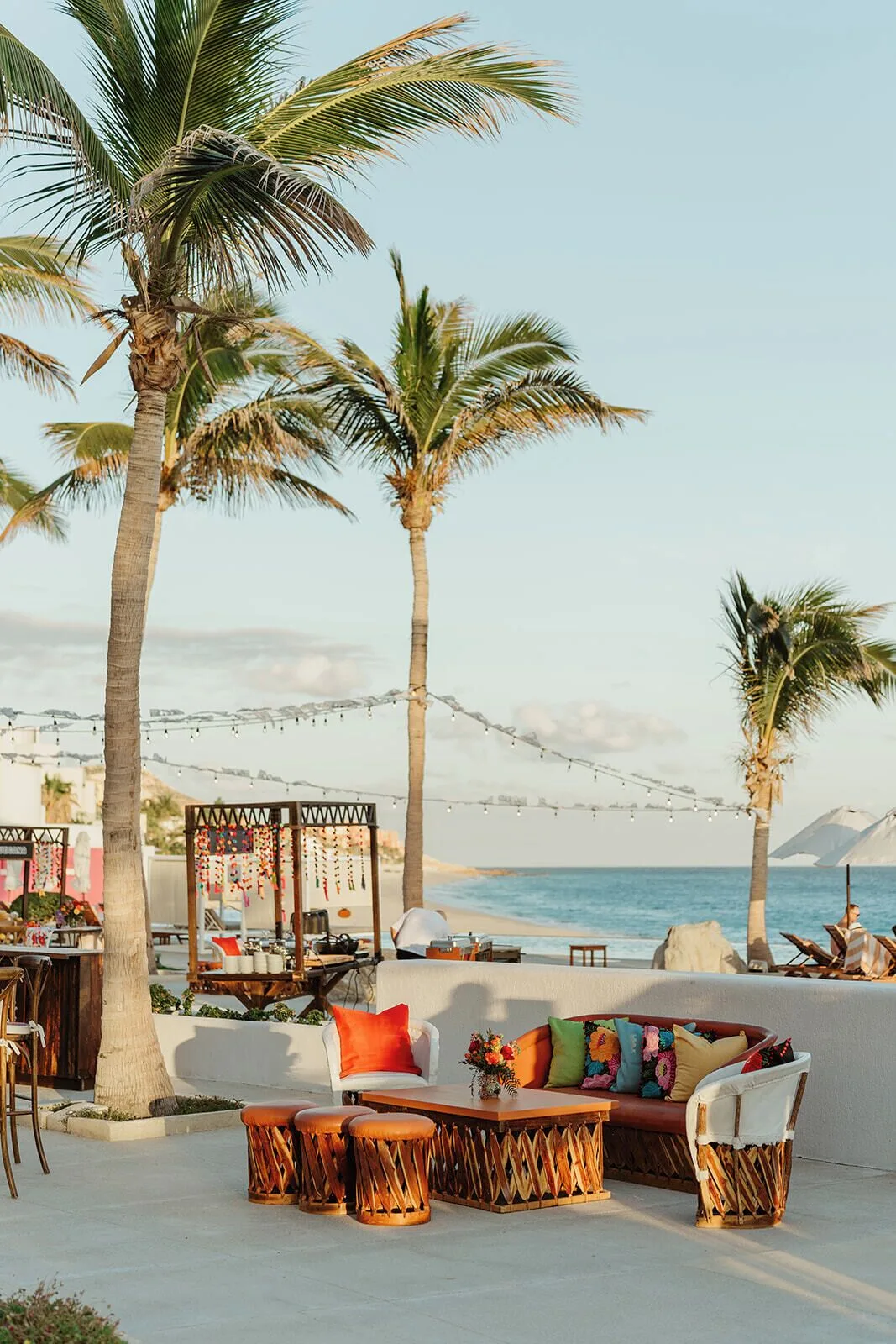 Outdoor lounge seating with palm trees and ocean view at Marquis Los Cabos.
