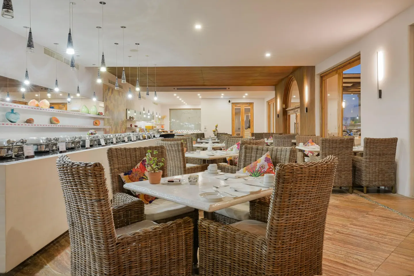 Buffet dining room with wicker chairs and chafing dishes at Marquis Los Cabos.