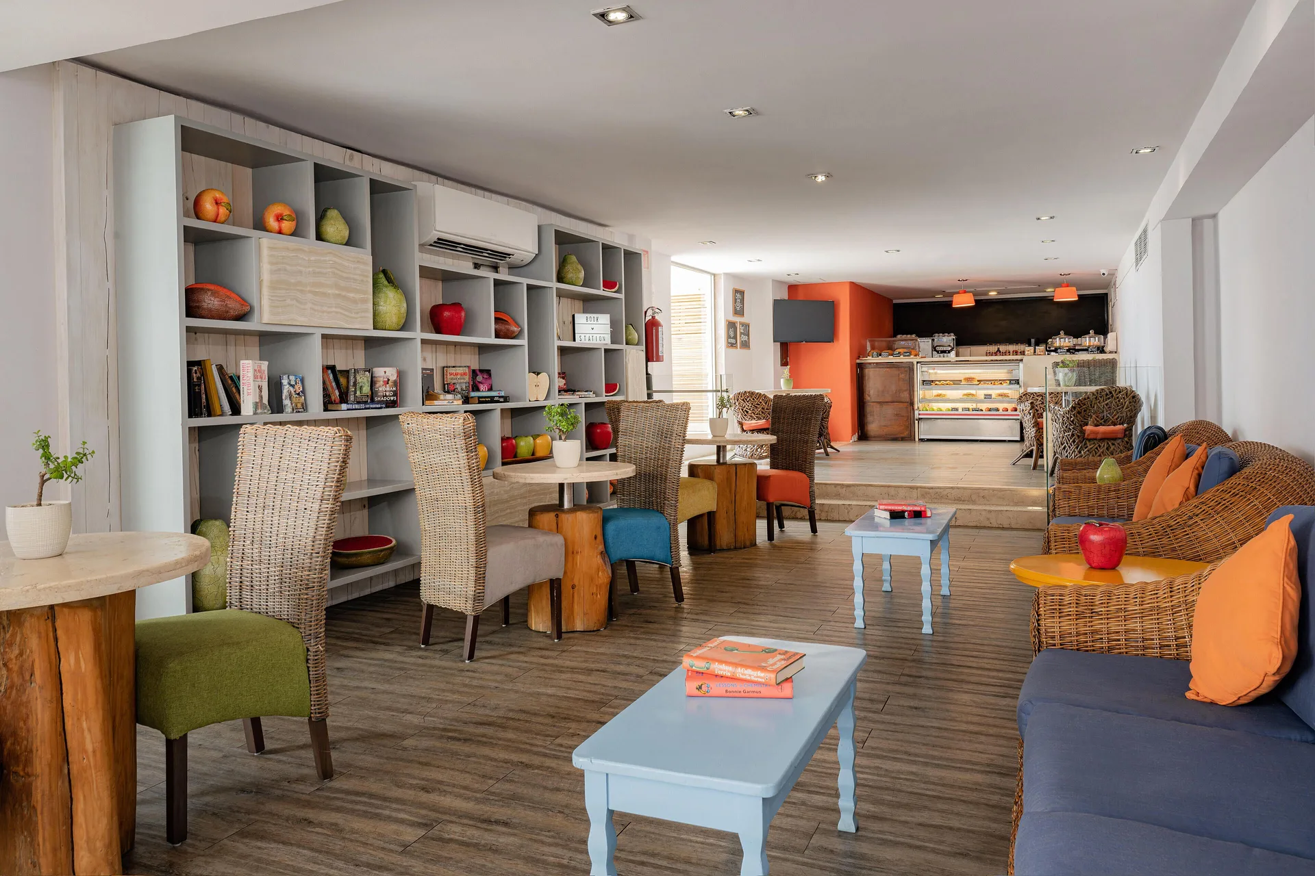 Casual café lounge with wicker seating and pastry case at Marquis Los Cabos.