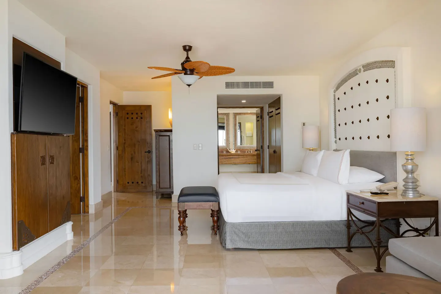 Garden View Casita king bedroom with TV and bath entrance at Marquis Los Cabos.