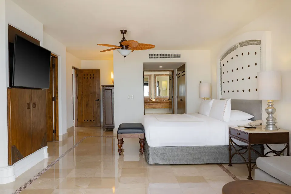 Garden View Casita king bedroom with TV and bath entrance at Marquis Los Cabos.