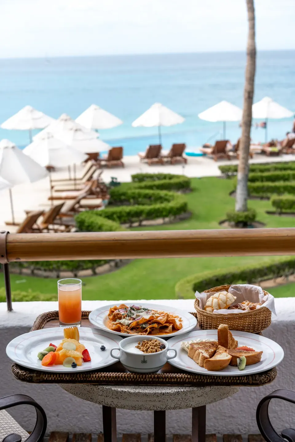 Balcony breakfast in a Junior Suite Ocean View at Marquis Los Cabos overlooking the pool and sea.