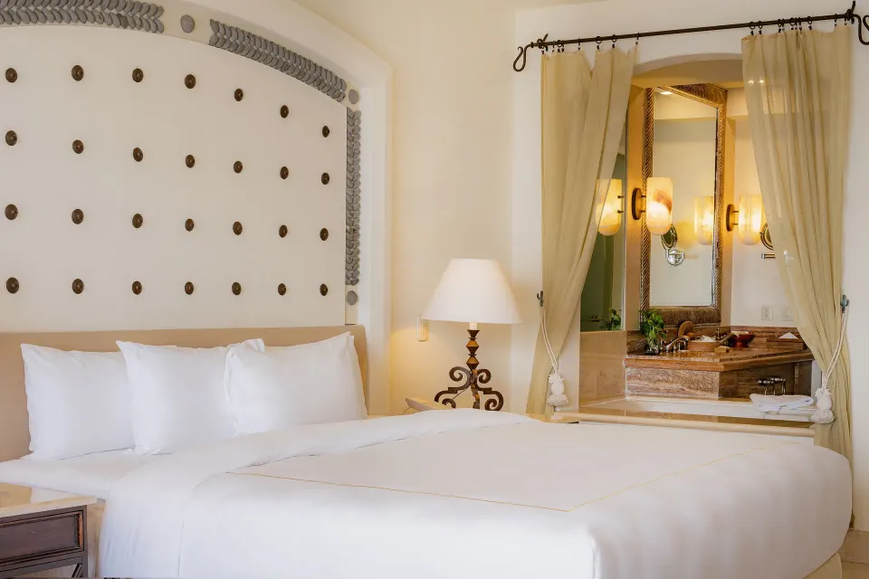 King bed and open bathroom vanity in a Junior Suite Ocean View at Marquis Los Cabos.