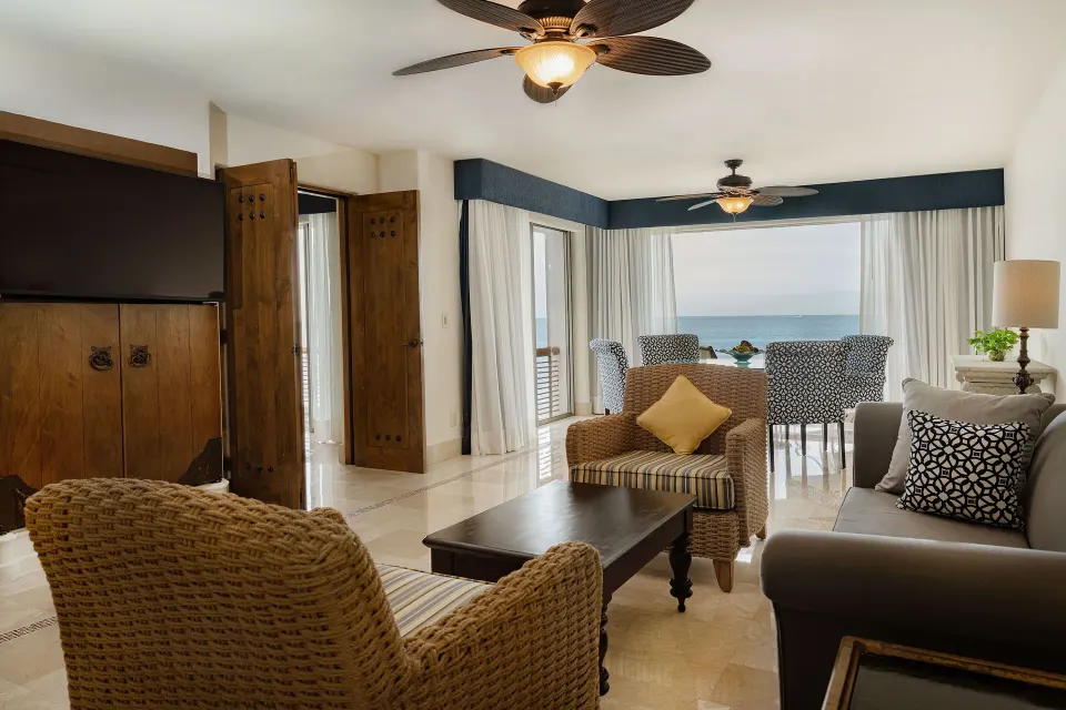 Oceanfront Casita living room with seating, TV, and ocean-facing windows at Marquis Los Cabos.
