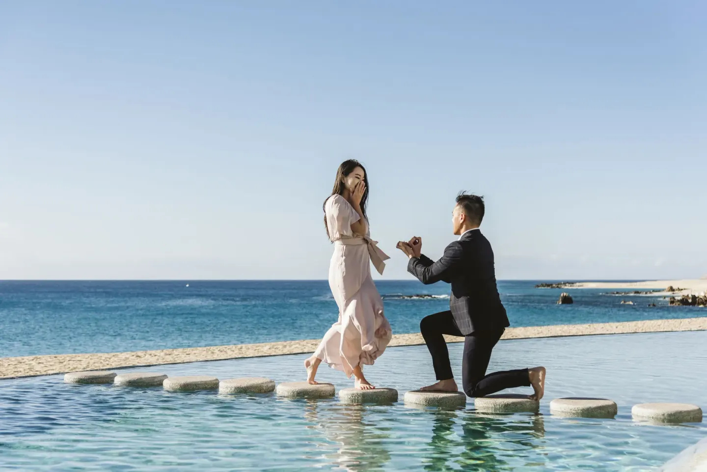 A beachside proposal on stepping stones over the pool at Marquis Los Cabos.