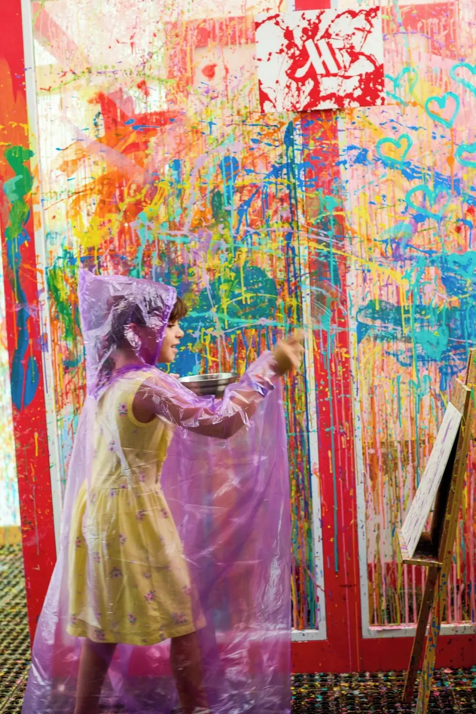 Child paints beside a colorful splattered wall at Marriott Cancun.