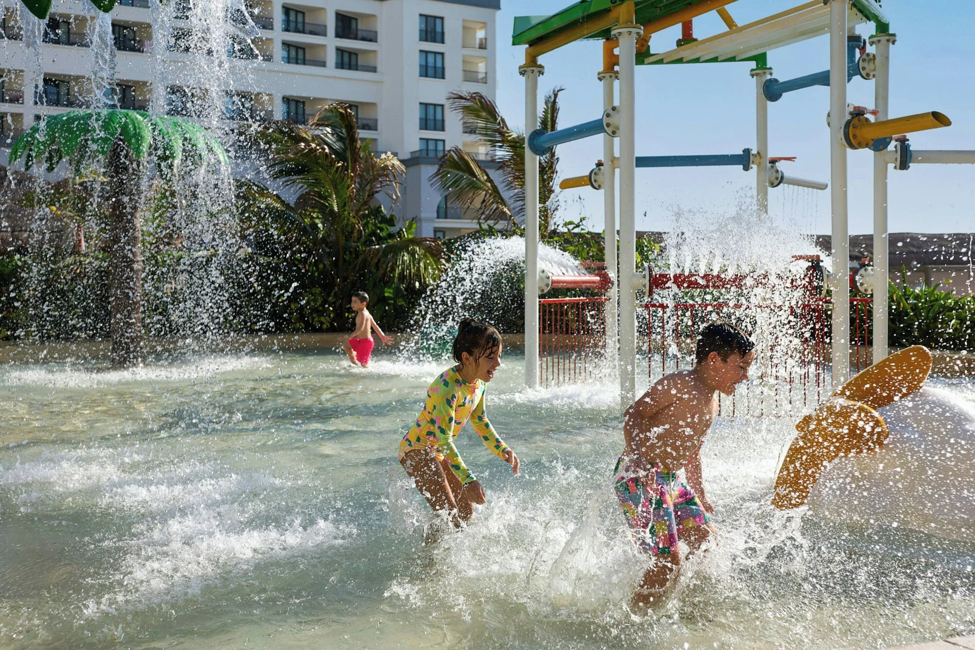 Children run through a splash pad with water features at Marriott Cancun.