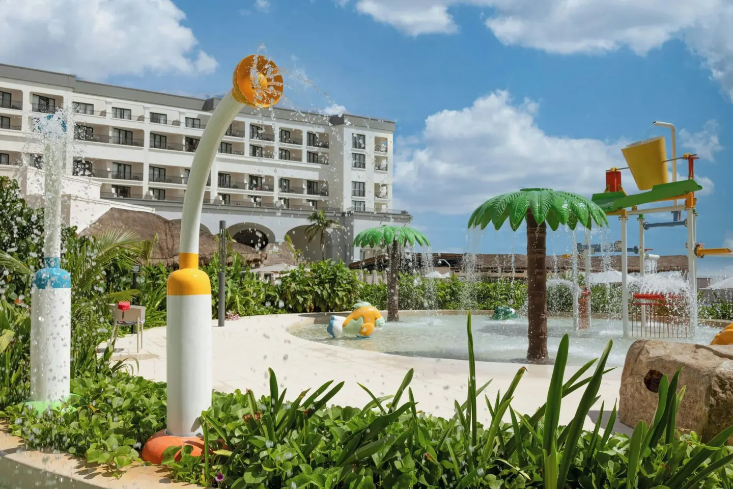 Splash pad with spray features and resort building at Marriott Cancun.