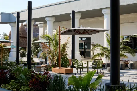 Garden patio with umbrellas, palms, and café tables at Marriott Cancun.