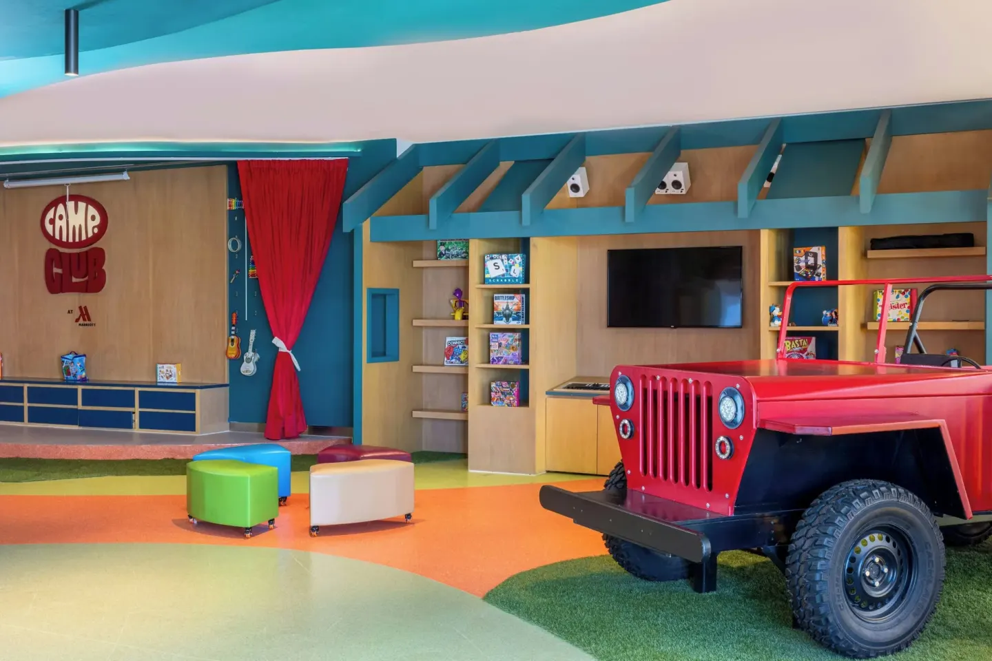 Colorful kids' club playroom with red toy vehicle at Marriott Cancun.