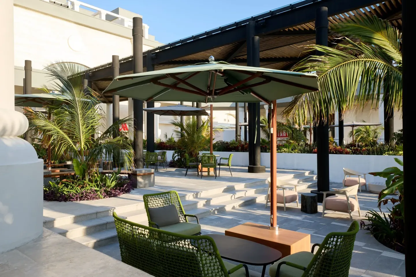 Outdoor patio seating with umbrellas and palms at Marriott Cancun.