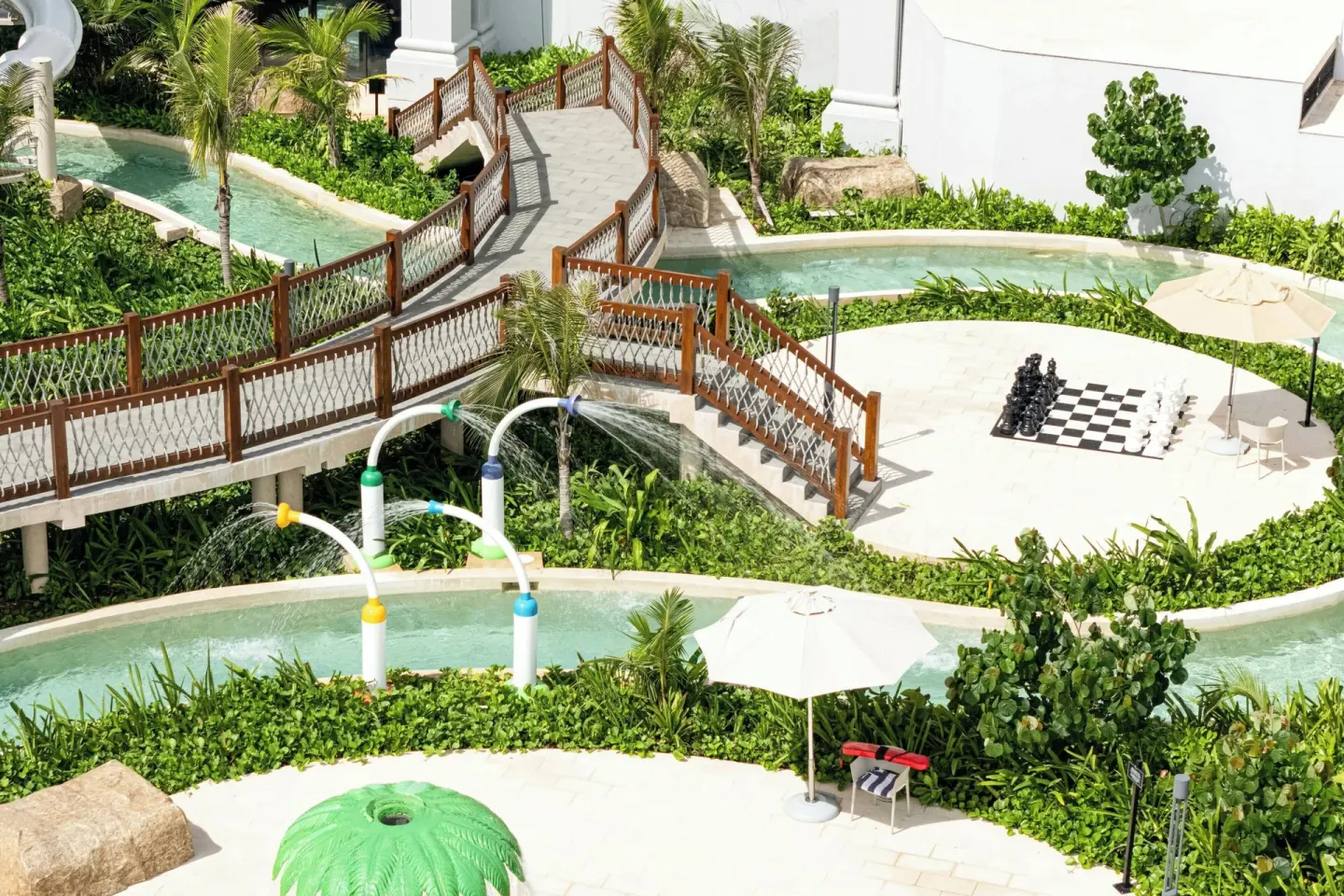 A landscaped outdoor water play area with bridges and a chess set at Marriott Cancun.