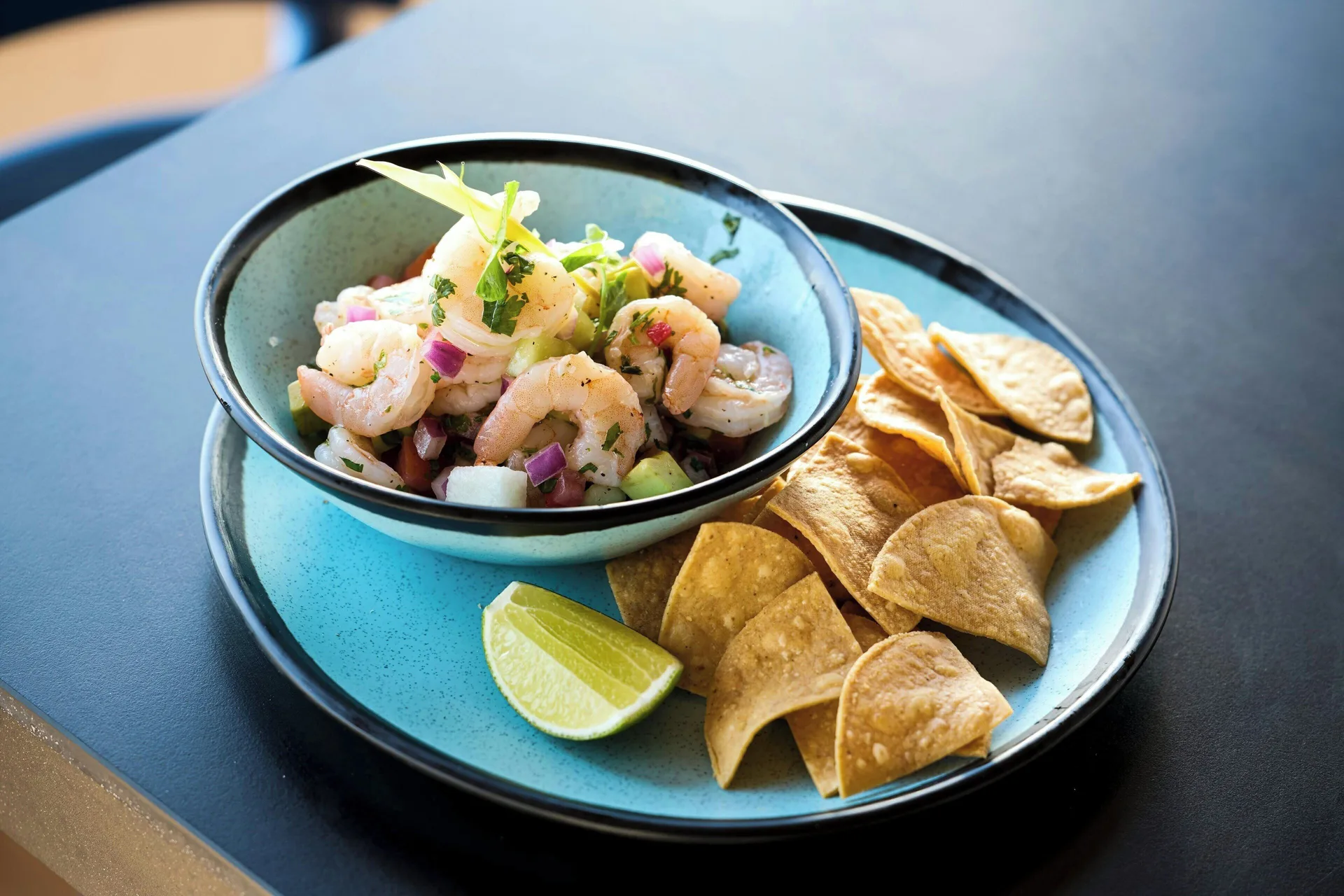 Shrimp ceviche with tortilla chips and lime on a blue plate at Marriott Cancun.