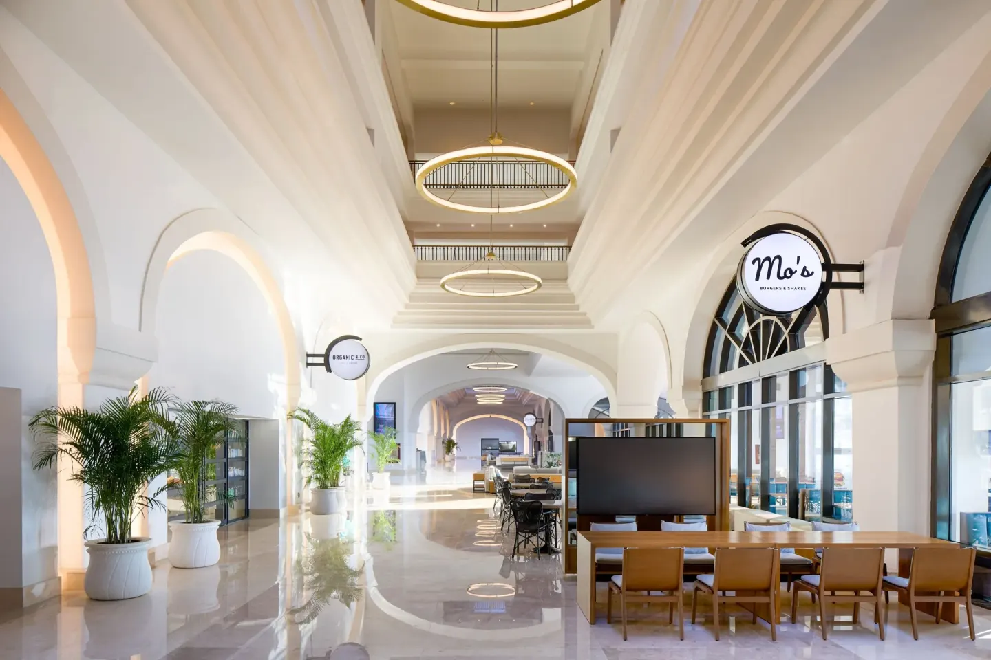 Indoor arcade with Mo's Burgers & Shakes signage and seating at Marriott Cancun.