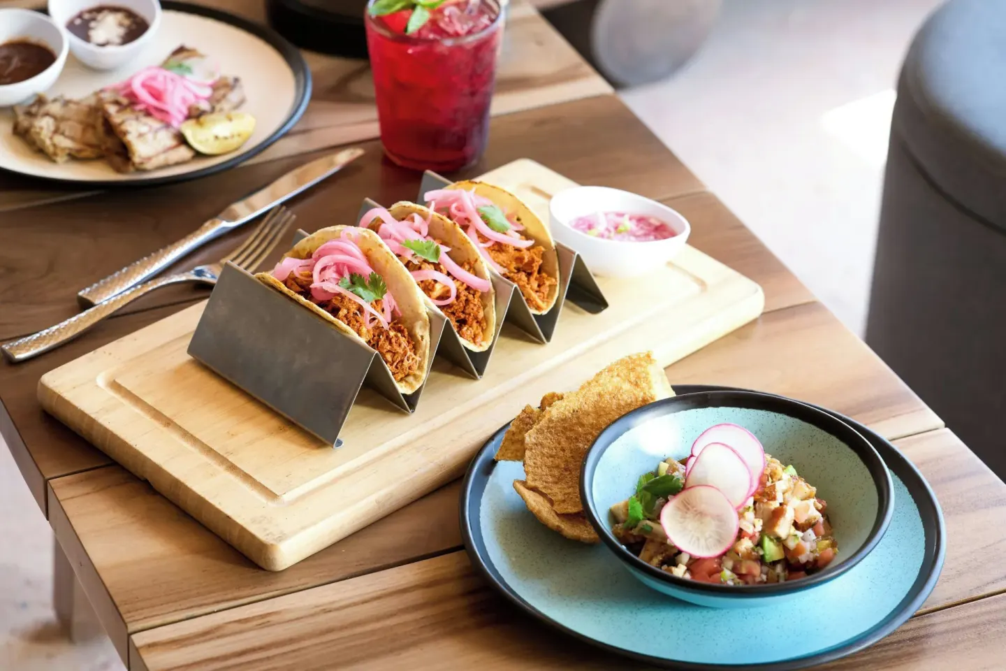 Tacos, ceviche, grilled seafood, and drinks on a wooden table at Marriott Cancun.