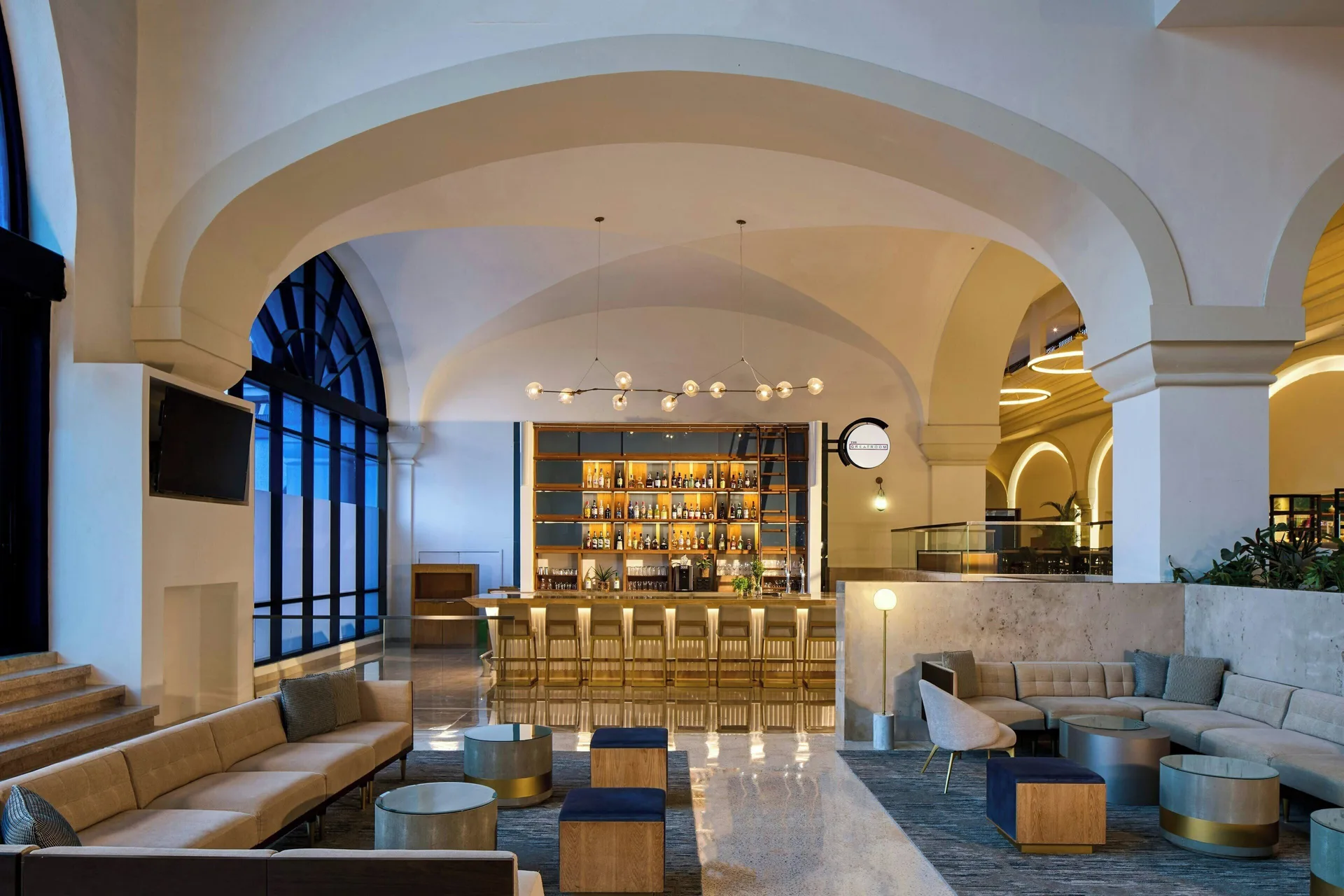 Lobby bar with arched ceilings, lounge seating, and backlit bottles at Marriott Cancun.