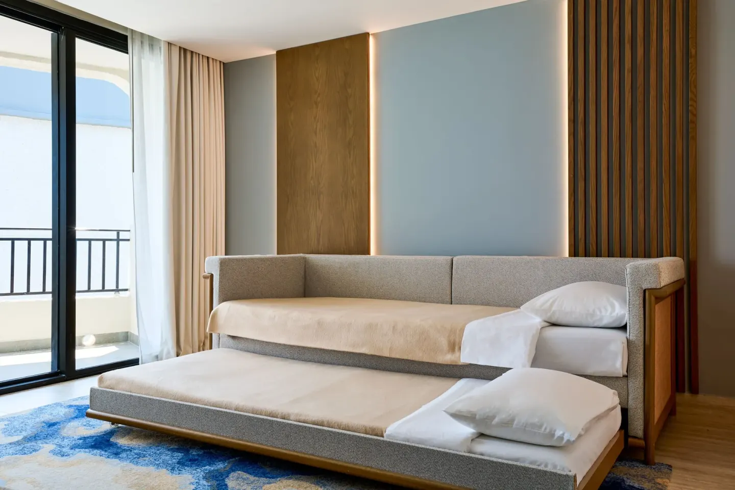 Executive Suite sofa bed opened with pillows near balcony doors at Marriott Cancun.