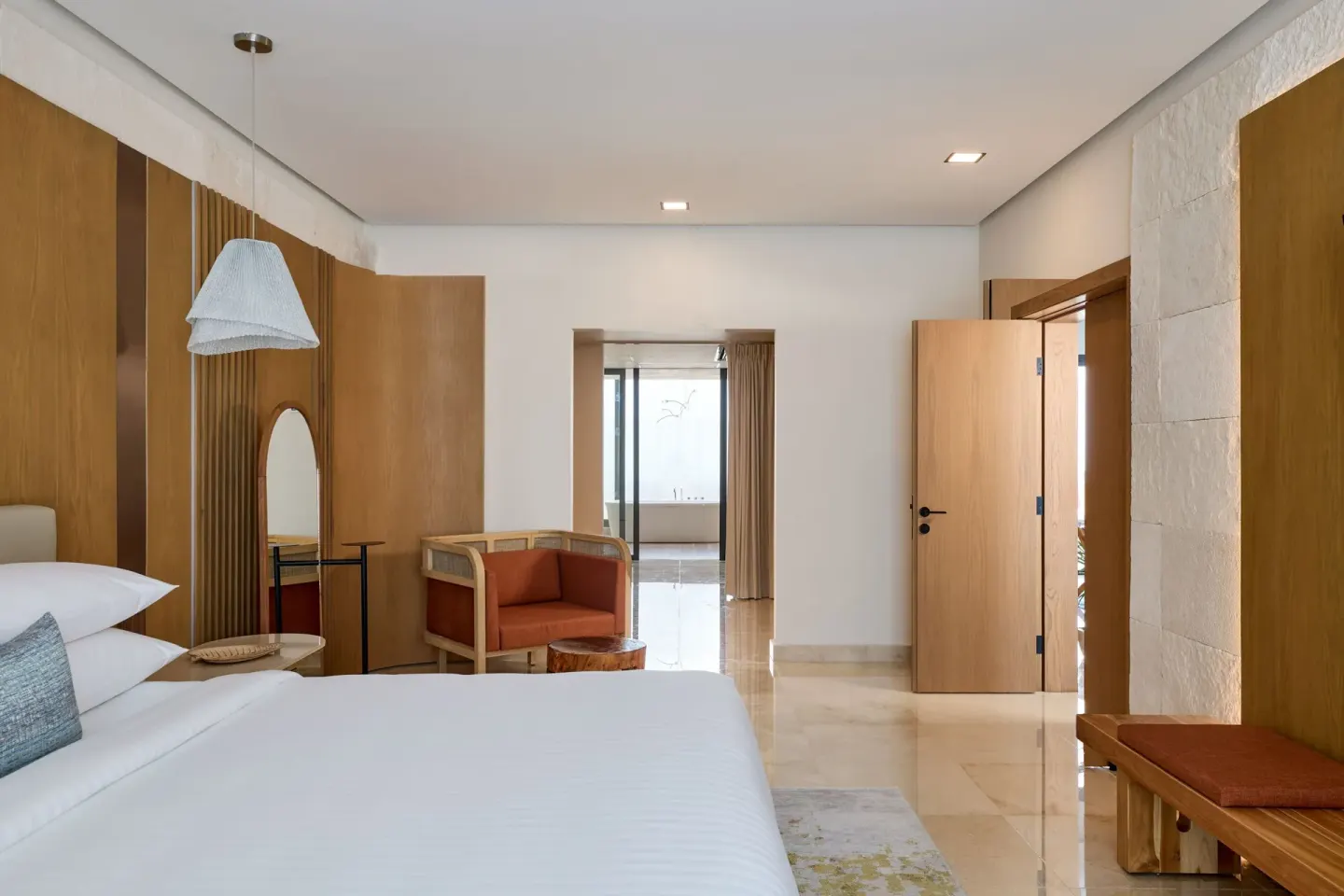 Presidential Suite bedroom with king bed and sitting chair at Marriott Cancun.