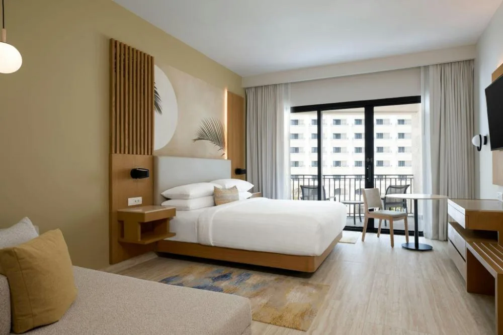 Resort view king guest room with sofa bed and balcony at Marriott Cancun.