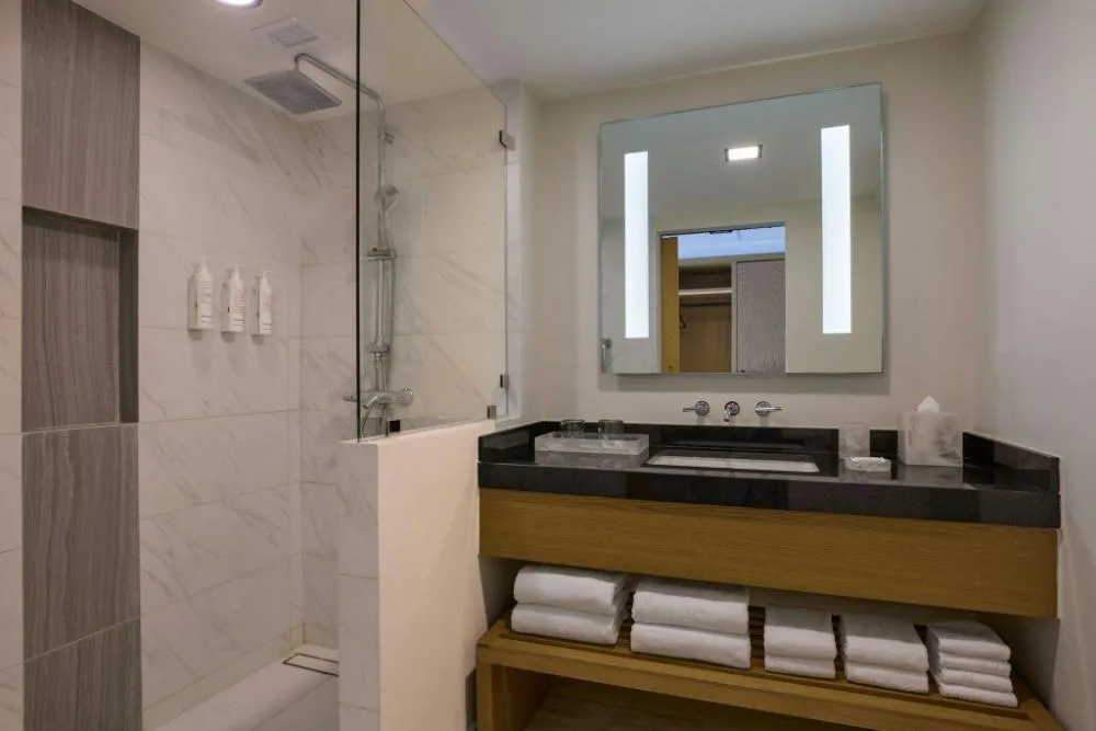 Bathroom with glass shower, vanity, and towels in a guest room at Marriott Cancun.