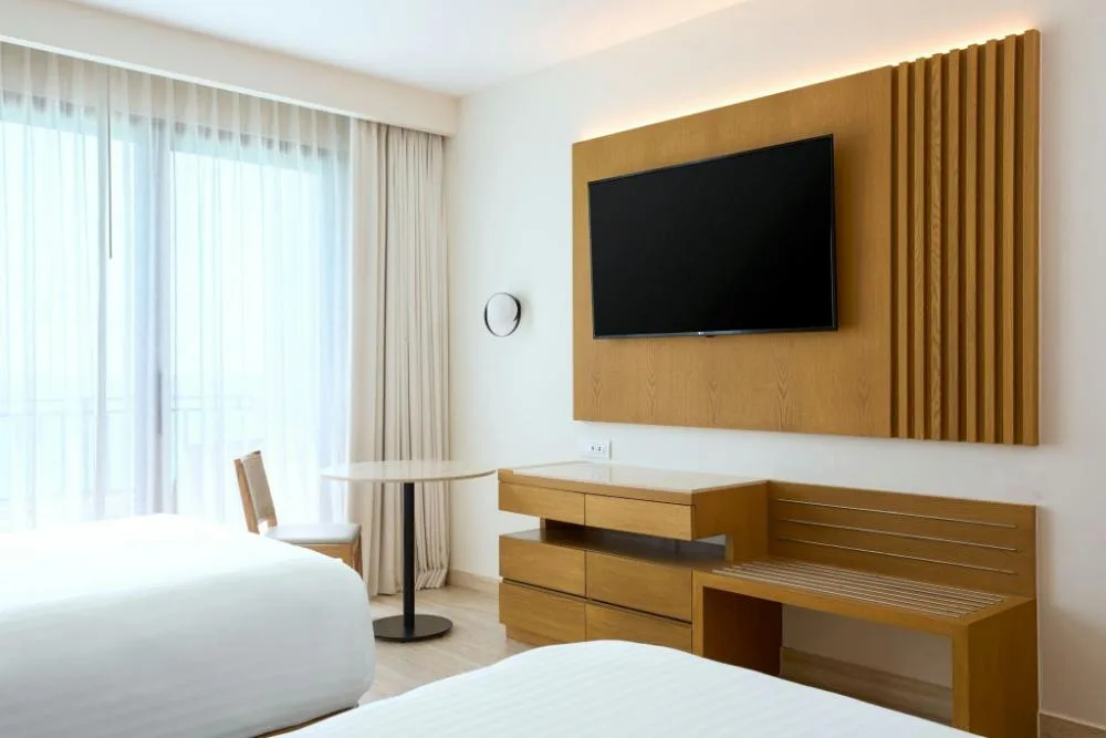 Resort View guest room with two beds, TV wall, and balcony curtains at Marriott Cancun.