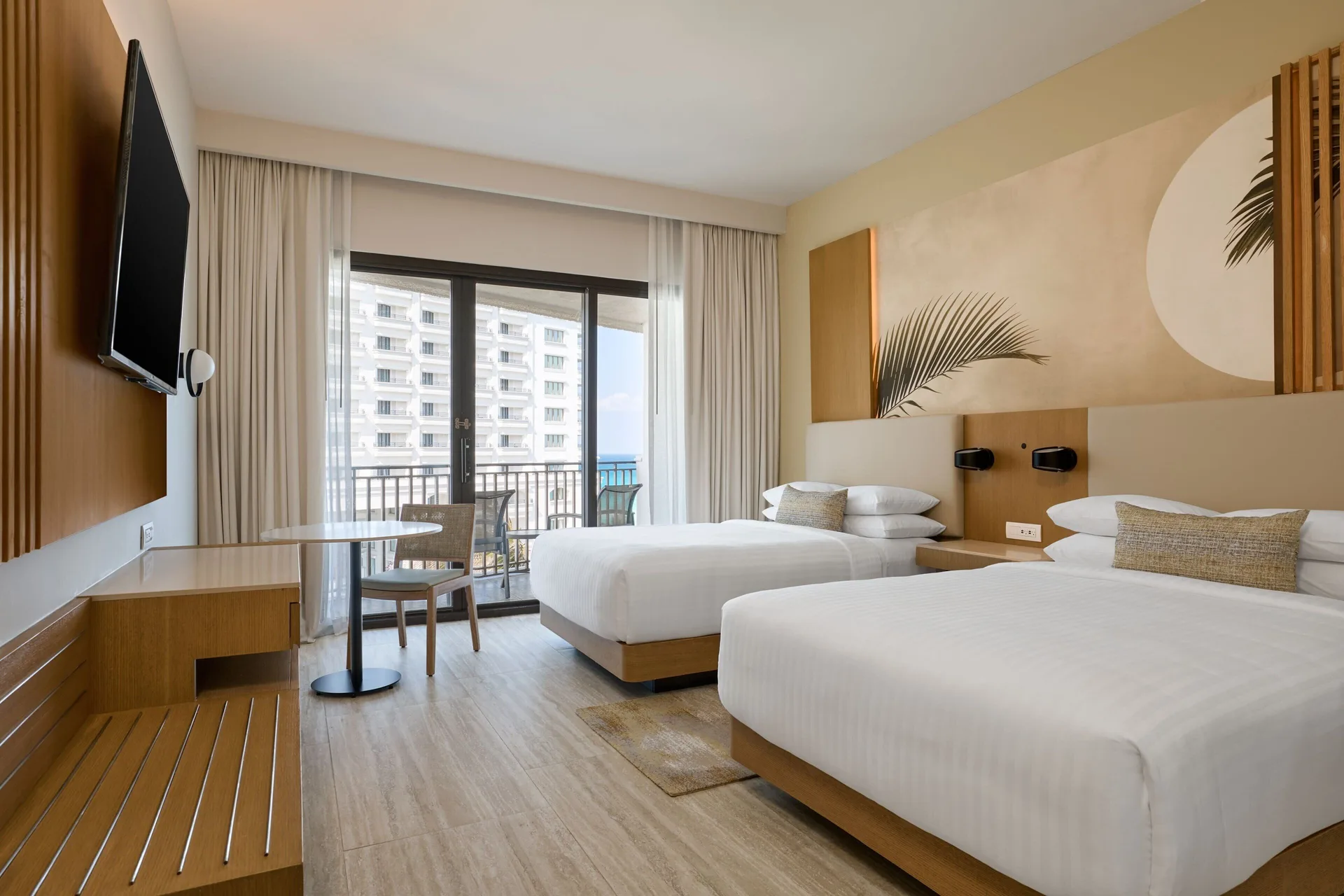 Two double beds and a balcony with resort view in a guest room at Marriott Cancun.