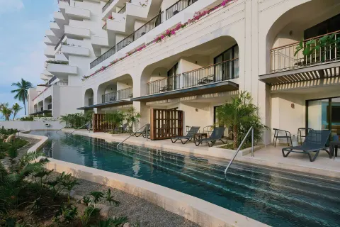Long pool beside balconies and lounge chairs at Marriott Puerto Vallarta Resort & Spa.
