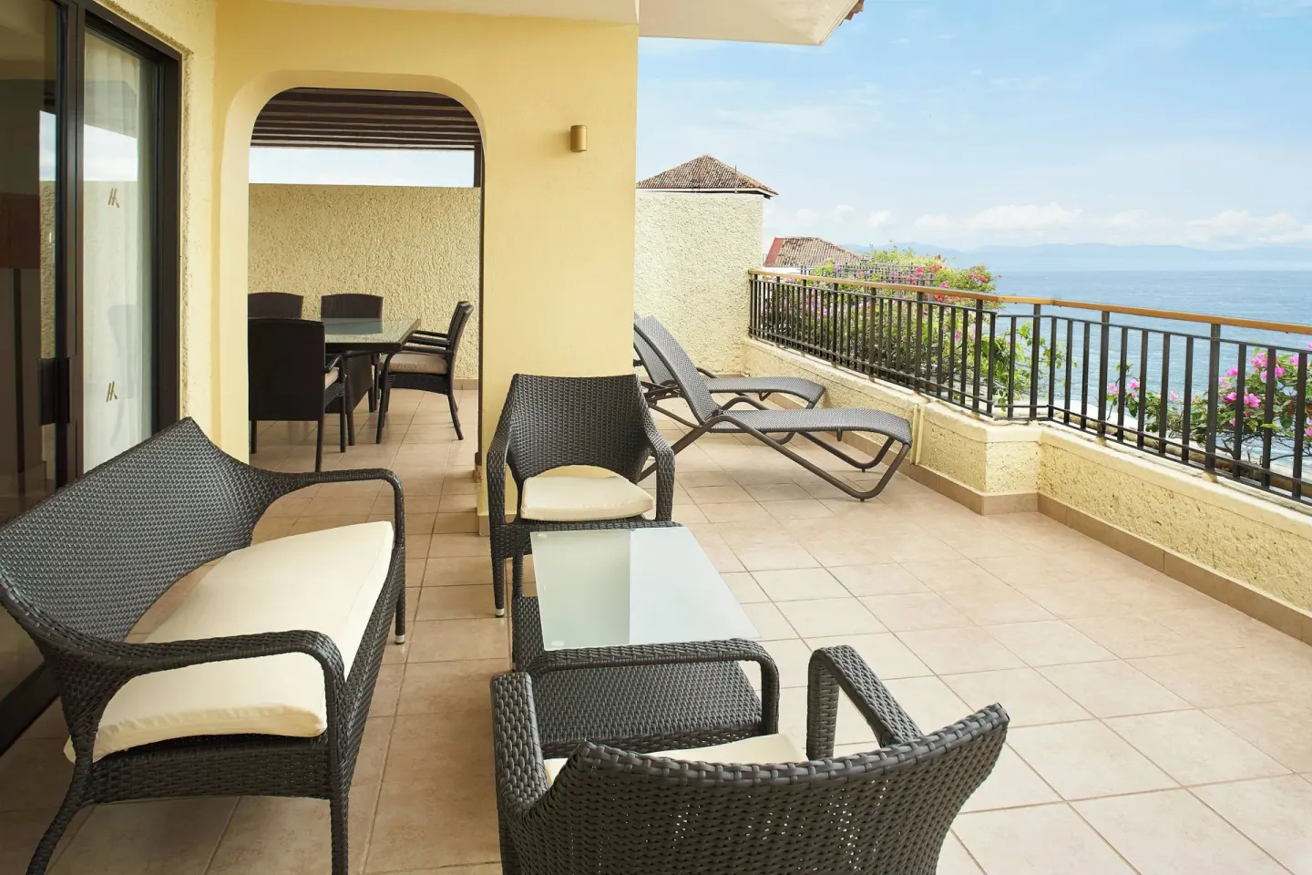 Ocean-view terrace with wicker seating and lounge chairs at Marriott Puerto Vallarta Resort & Spa.