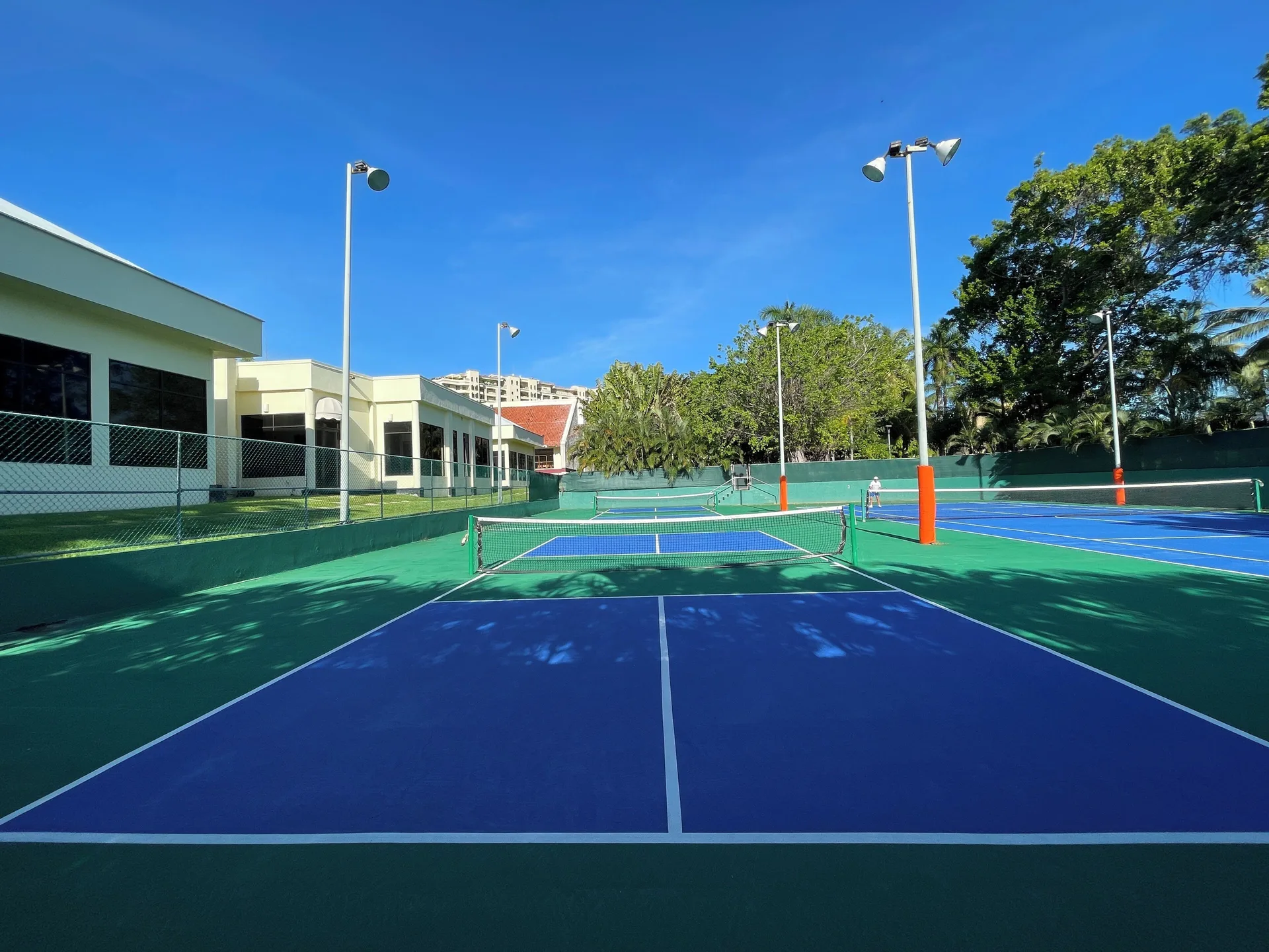 Outdoor tennis courts under a clear blue sky at Marriott Puerto Vallarta Resort & Spa.
