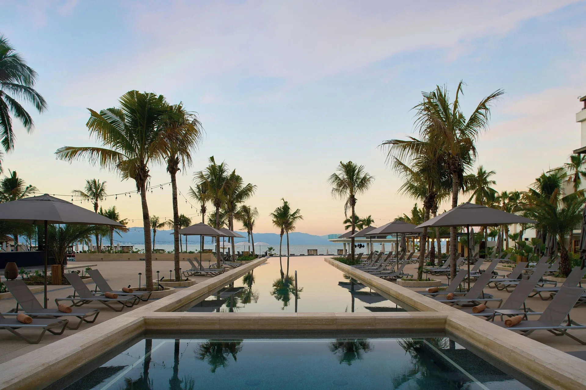 Palm-lined resort pool with loungers at Marriott Puerto Vallarta Resort & Spa.