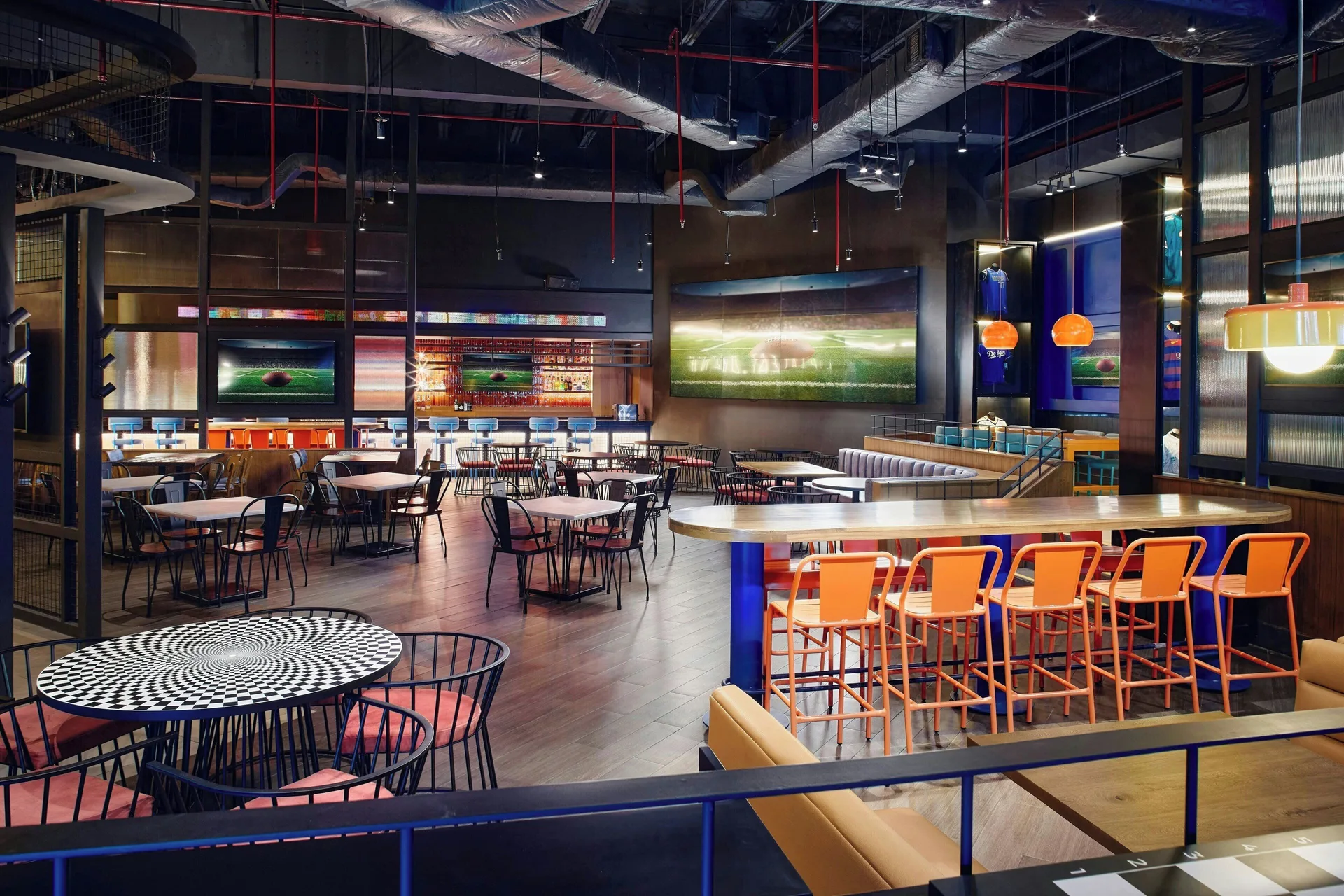 Sports bar with high-top seating, tables and large screens at Marriott Puerto Vallarta Resort & Spa.