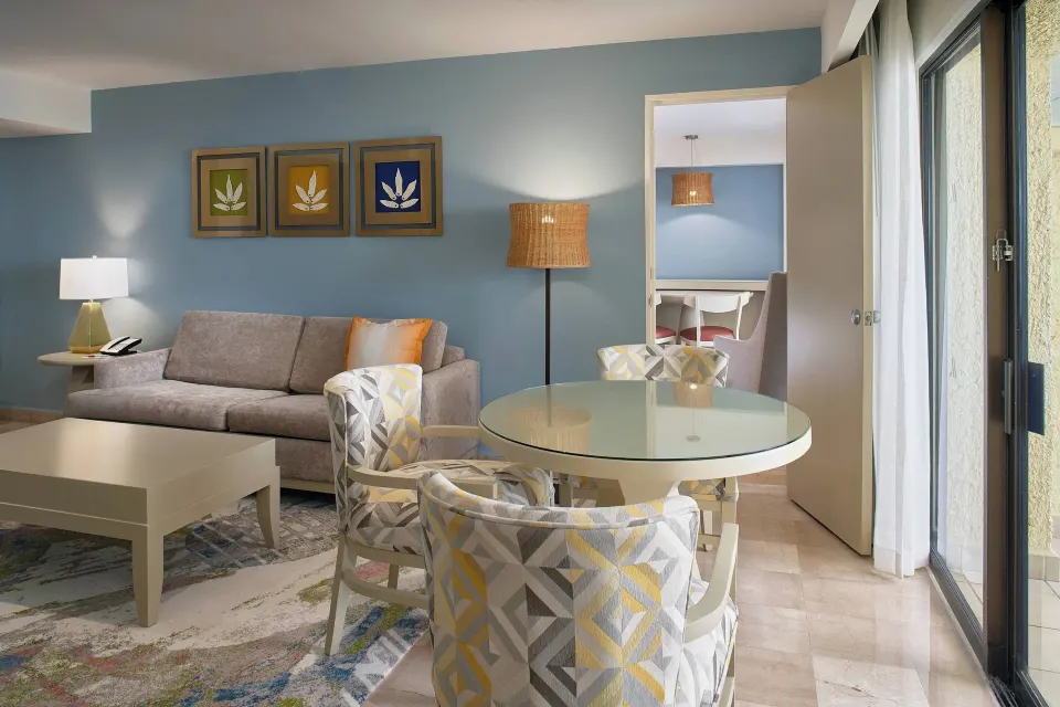Junior Suite ocean-view sitting area at Marriott Puerto Vallarta Resort & Spa with sofa and round dining table.