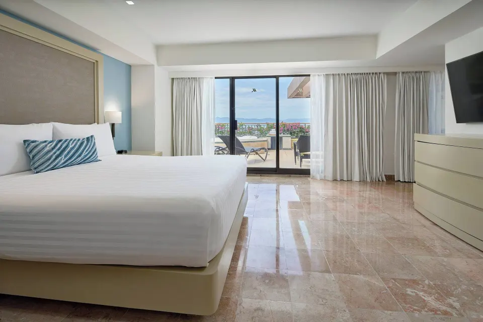 Luxury Suite bedroom with king bed and terrace view at Marriott Puerto Vallarta Resort & Spa.