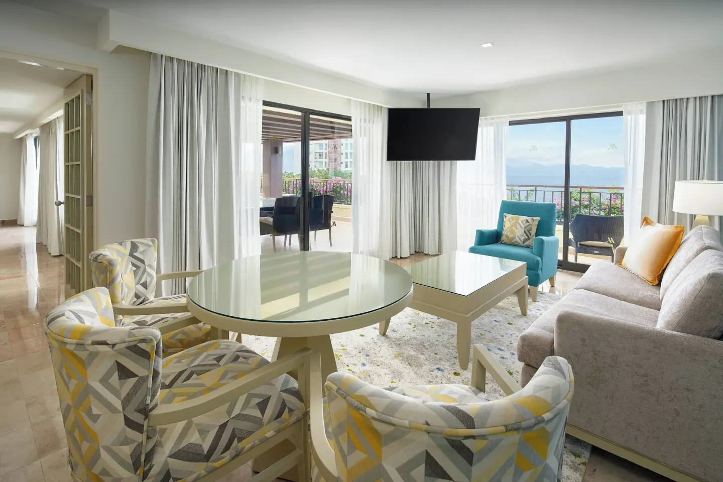 Luxury Suite living room with dining table and balcony views at Marriott Puerto Vallarta Resort & Spa.