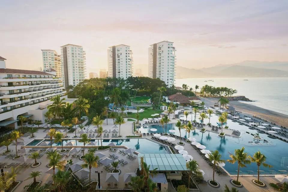 Balcony view over pools, palms, beach, and ocean at Marriott Puerto Vallarta Resort & Spa.