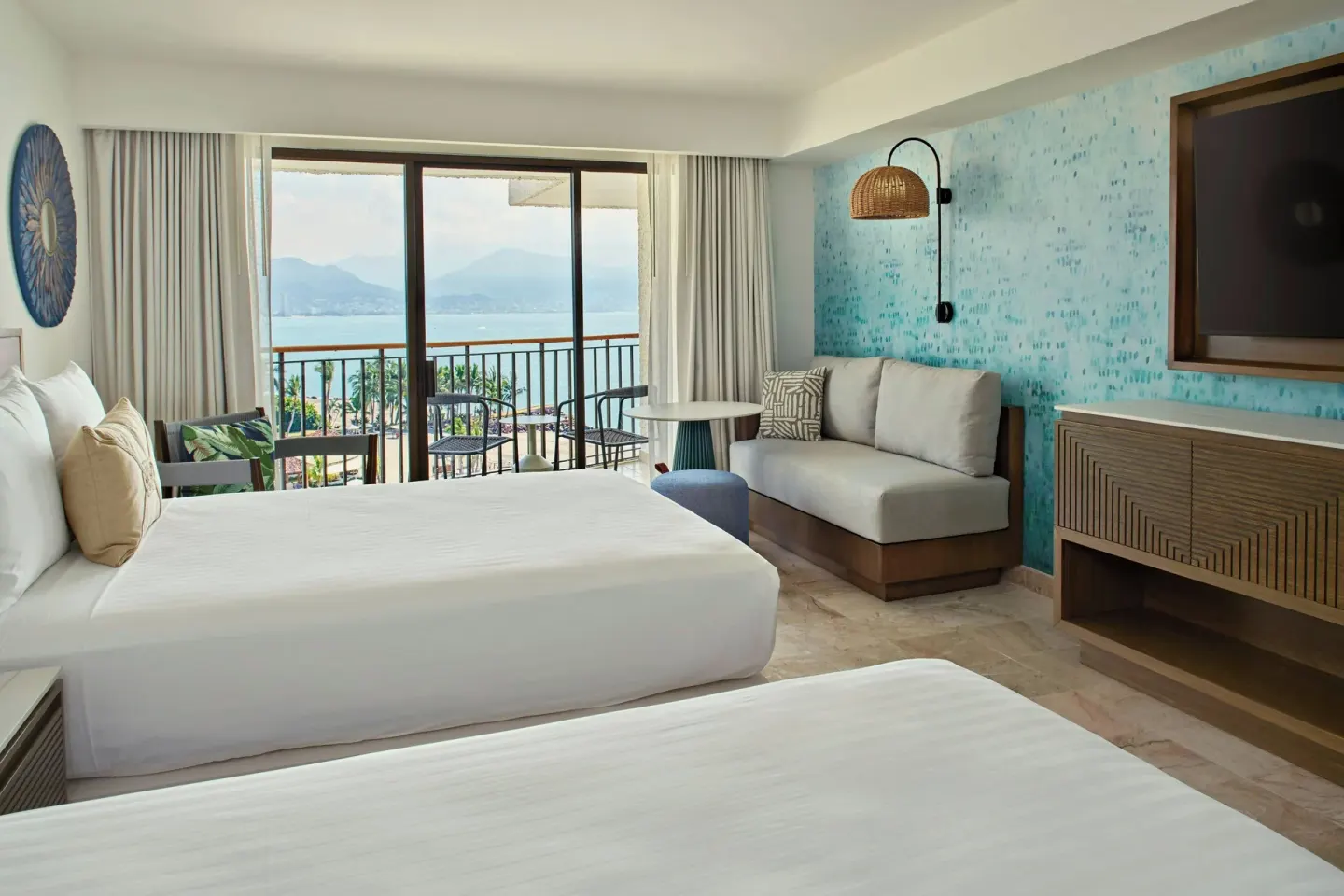 Panoramic ocean-view balcony room with two beds at Marriott Puerto Vallarta Resort & Spa.
