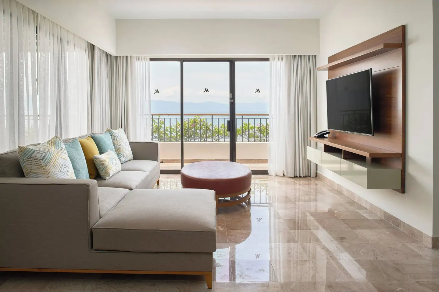 Suite sitting room with sofa and balcony view at Marriott Puerto Vallarta Resort & Spa.