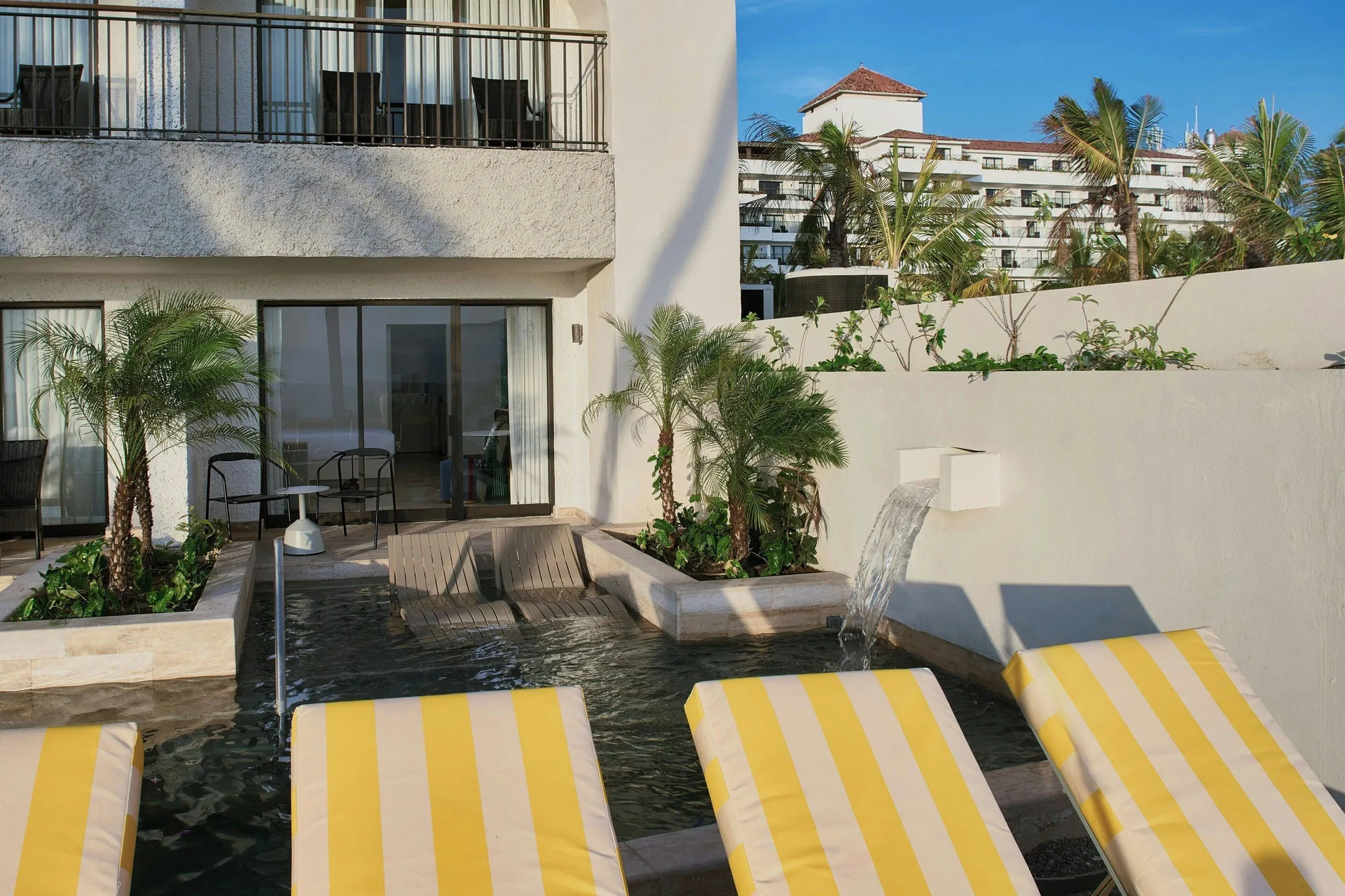 Oceanfront room terrace with swim-up pool and loungers at Marriott Puerto Vallarta Resort & Spa.