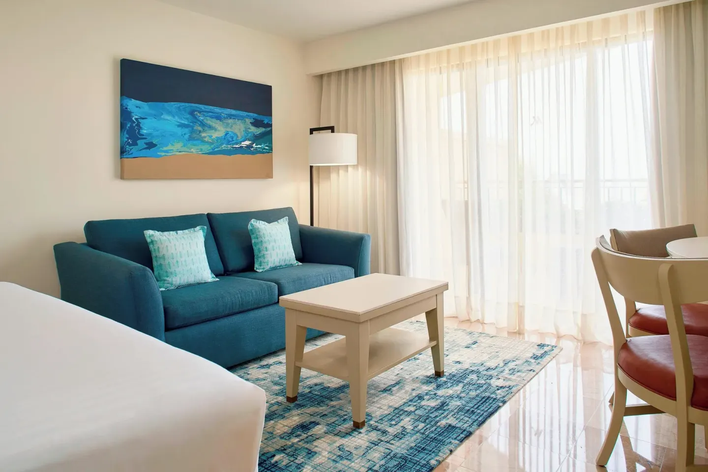 Guest room sitting area with sofa and balcony doors at Marriott Puerto Vallarta Resort & Spa.