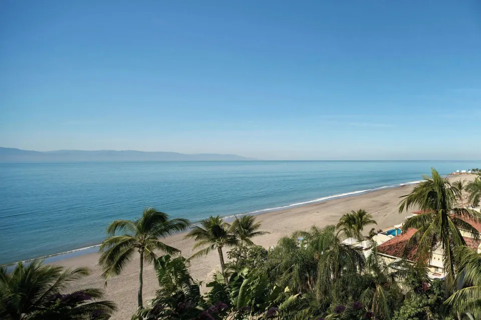 Guest room ocean view with beach and palms at Marriott Puerto Vallarta Resort & Spa.