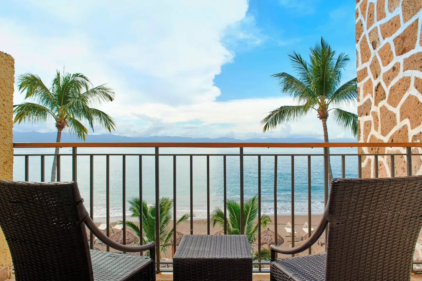 Guest room balcony with chairs and ocean view at Marriott Puerto Vallarta Resort & Spa.
