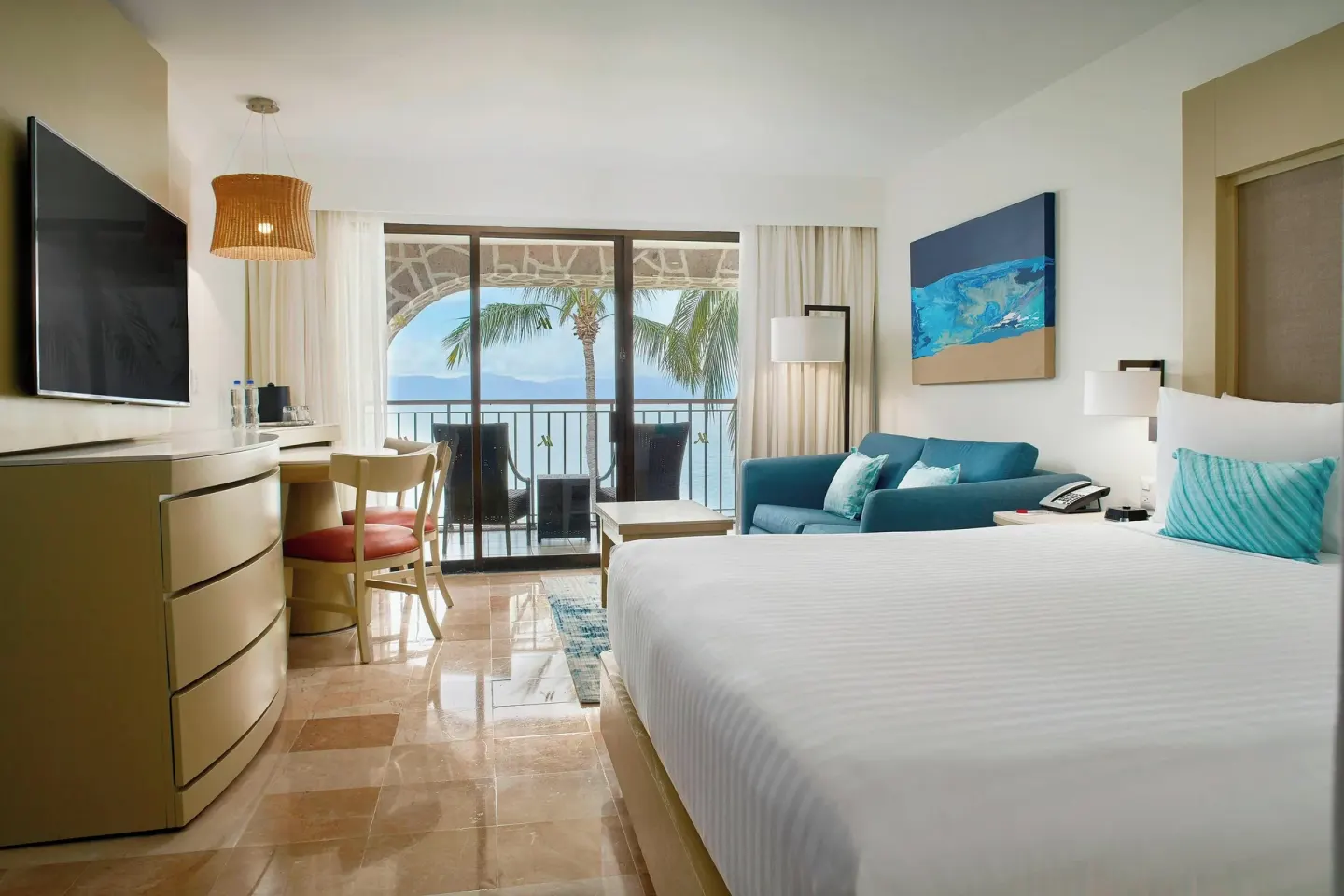 King bed guest room with sofa and ocean balcony at Marriott Puerto Vallarta Resort & Spa.