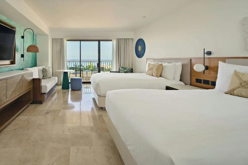 Guest room with two beds and balcony ocean view at Marriott Puerto Vallarta Resort & Spa.