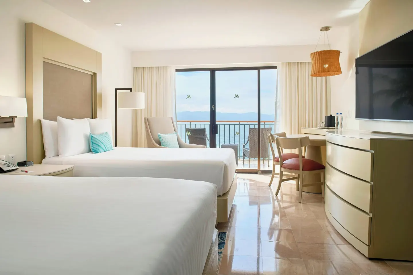 Guest room with two beds, desk, TV and balcony at Marriott Puerto Vallarta Resort & Spa.