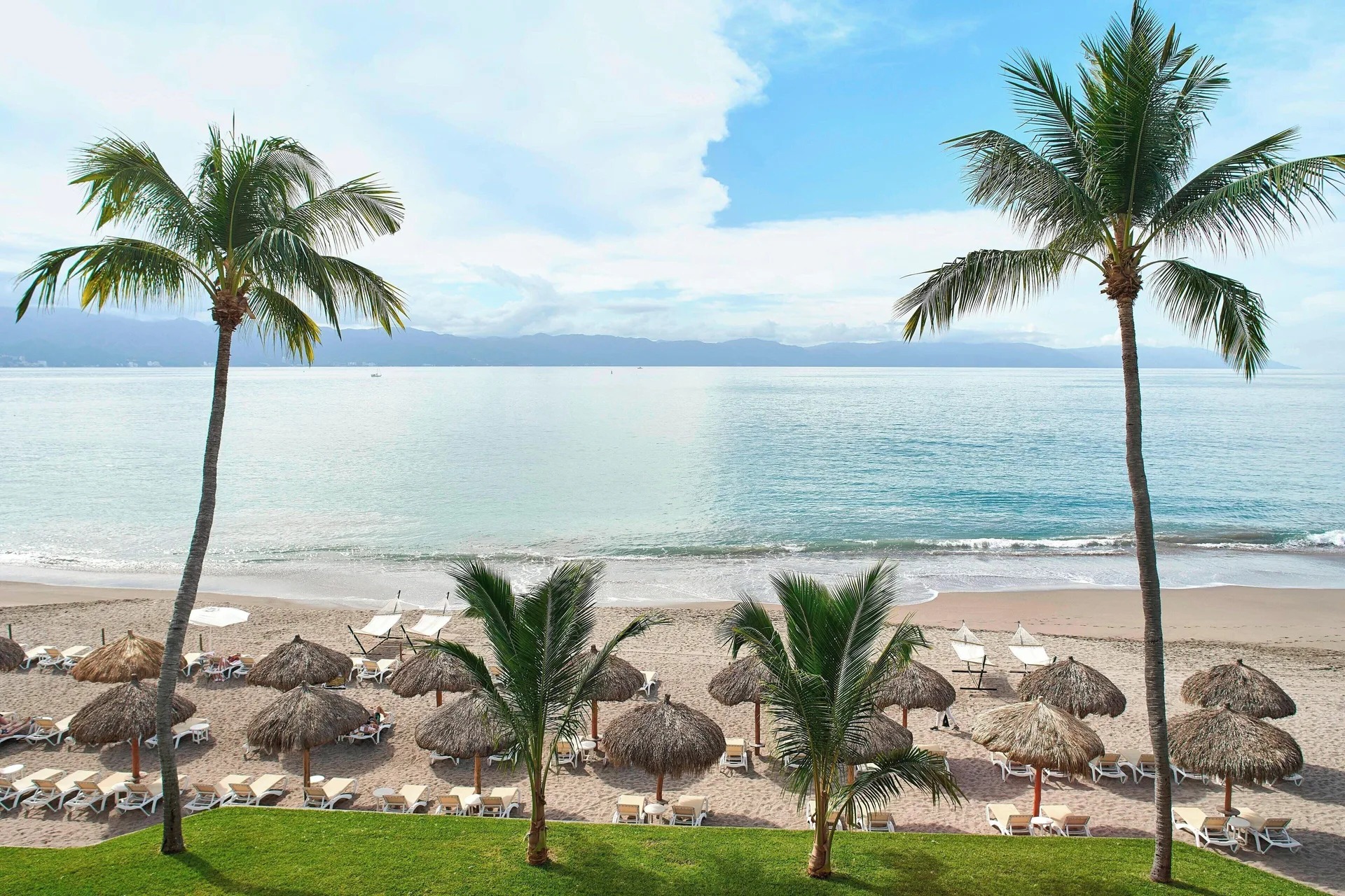 Oceanfront room view with palms and beach at Marriott Puerto Vallarta Resort & Spa.