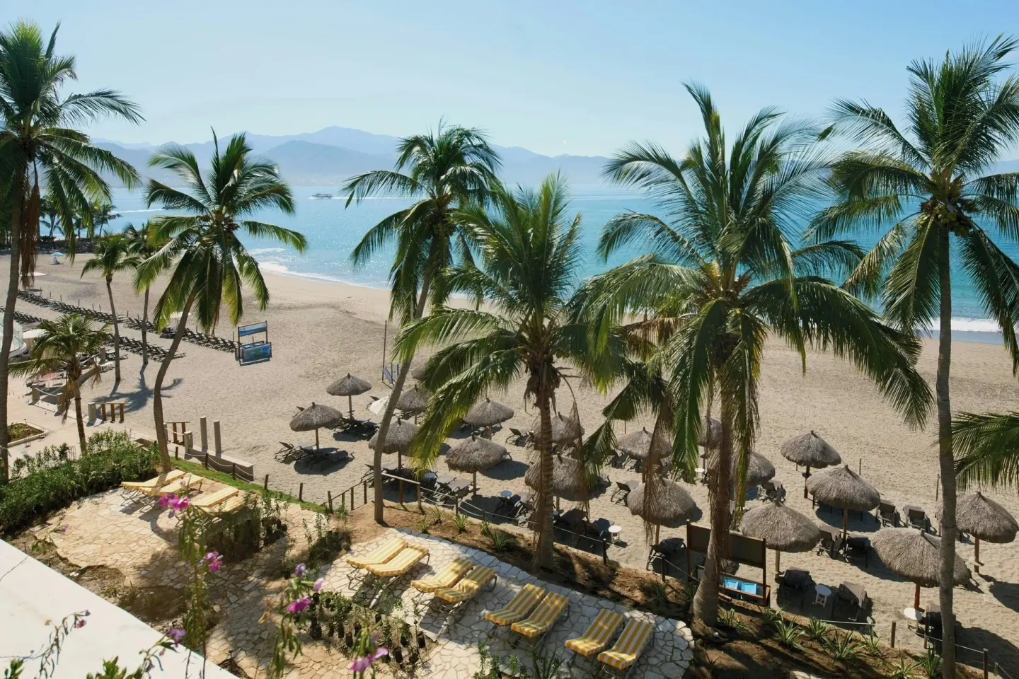 Guest room beach view with palms and palapas at Marriott Puerto Vallarta Resort & Spa.