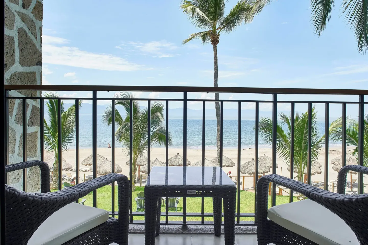 Oceanfront suite balcony at Marriott Puerto Vallarta Resort & Spa with chairs facing the beach and ocean.