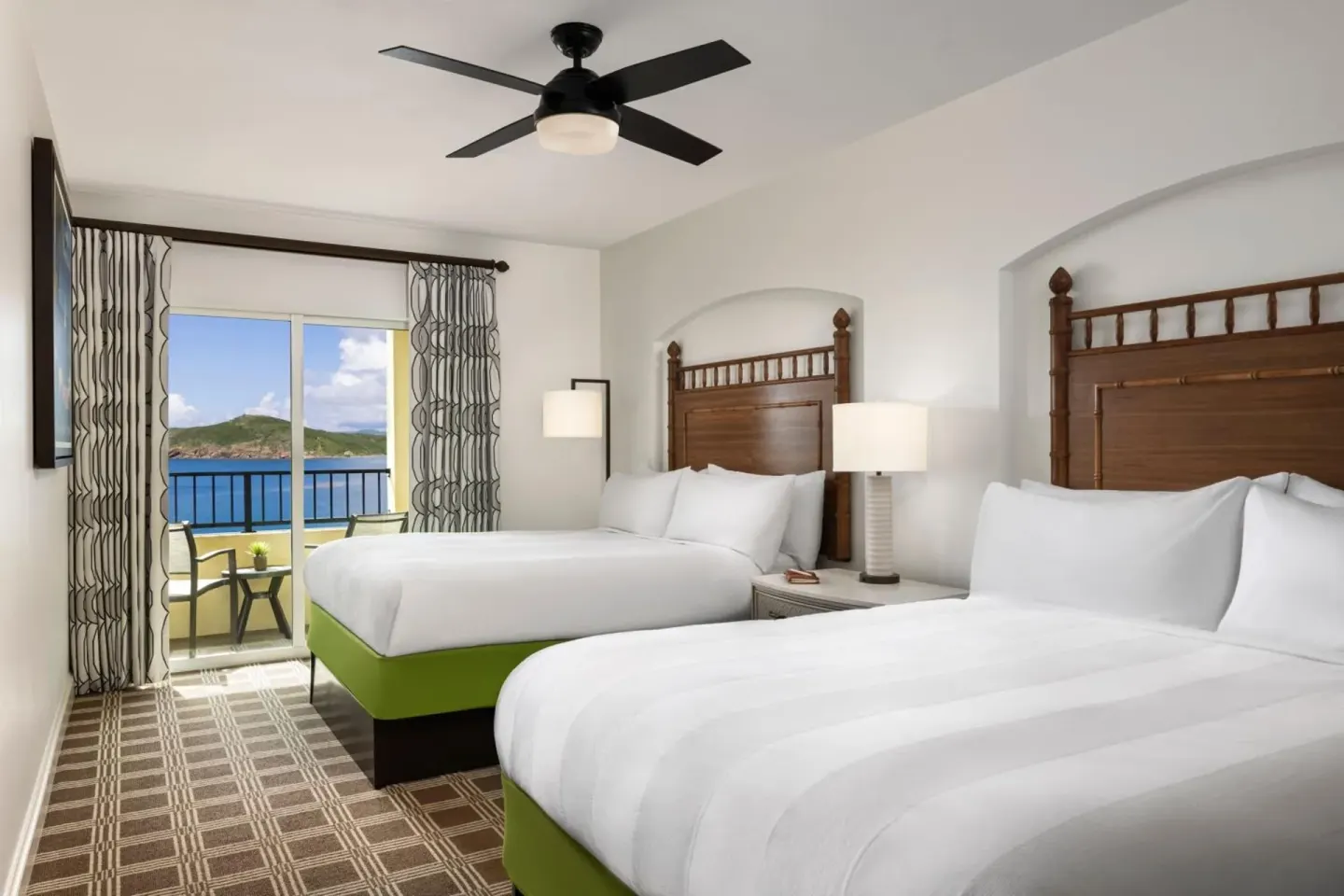 Guest bedroom with two beds and balcony water view at Marriott's Frenchman's Cove.