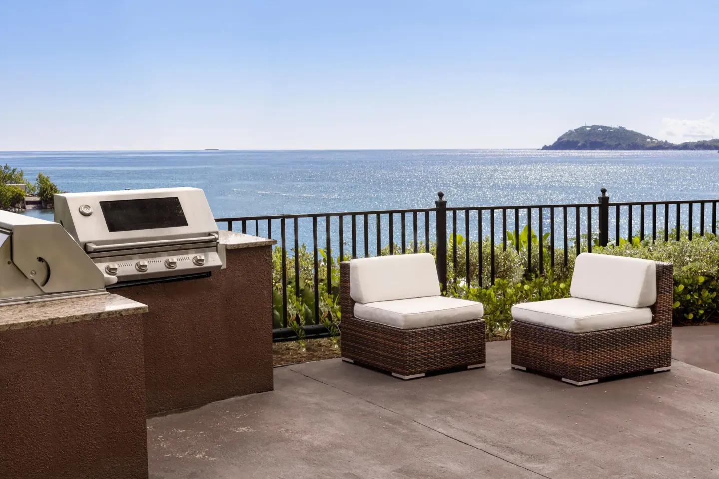 Outdoor grill and cushioned seating overlooking the sea at Marriott's Frenchman's Cove.