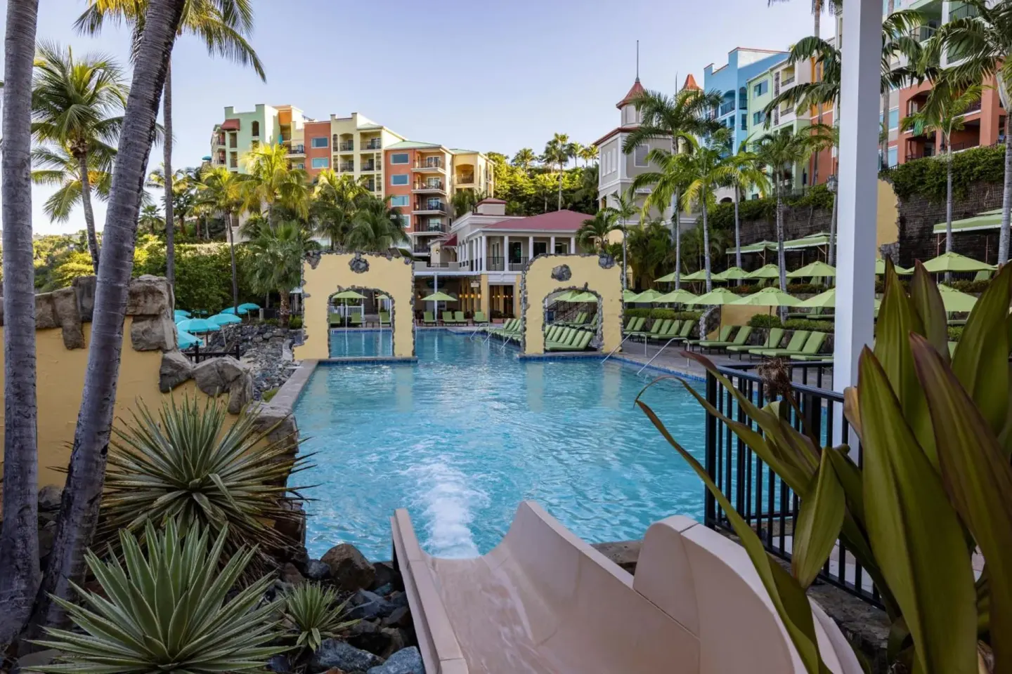 Pool with slide, loungers, and colorful buildings at Marriott's Frenchman's Cove.
